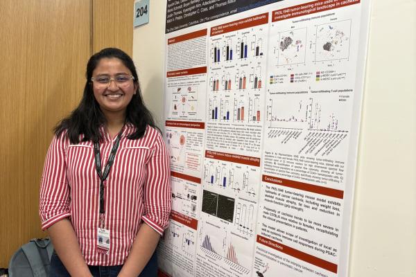 Ayushi Das in front of her research poster