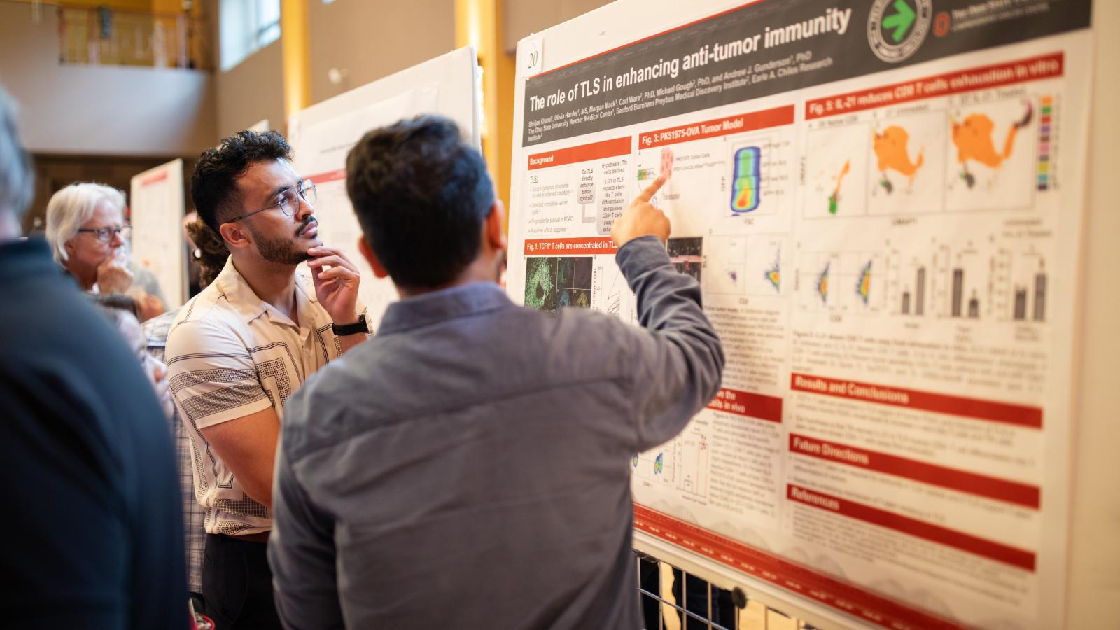 A student presenting their poster during a poster presentation